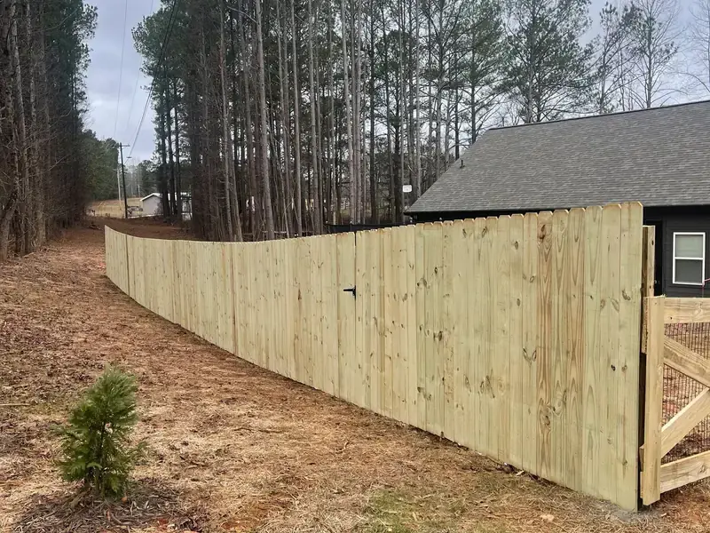 Wood privacy fence with a matching walk gate stepping down a sloped yard