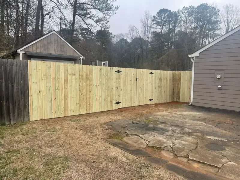 New wood privacy fence closing off the side yard between two houses